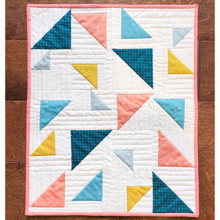 Triangular Quilt Pattern (Download) by Homemade Emily Jane featuring a modern geometric quilt with coral teal mustard and white triangle blocks on a wood background