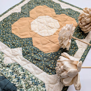 Close-up of a floral quilted table runner with blue and beige tones, handmade by Heart Lake Quilts featuring Trula's Blooms Table Runner Quilt Pattern (Download).