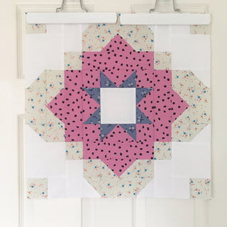 Quilt block featuring purple and blue geometric star shapes with floral and white background, showcasing the Vintage Tiles Quilt Pattern (Download) by Lou Orth Designs.