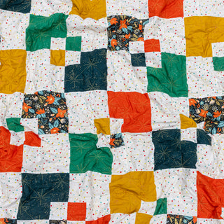 Colorful Welcome Party quilt by Trace Creek Quilting with geometric patterns on a white background