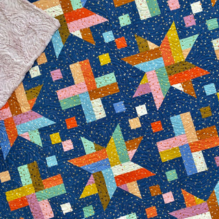 Wink quilt pattern by The Dandy Patch: colorful geometric quilt pattern on a blue background