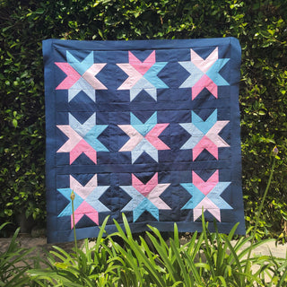 Beaming Quilt Pattern (Download) by Homemade Emily Jane featuring colorful star quilt blocks in blue pink and white for a modern geometric quilt design