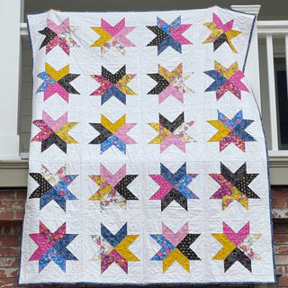 Beaming Quilt Pattern (Download) by Homemade Emily Jane featuring a colorful modern star quilt with bold geometric blocks on a white background.