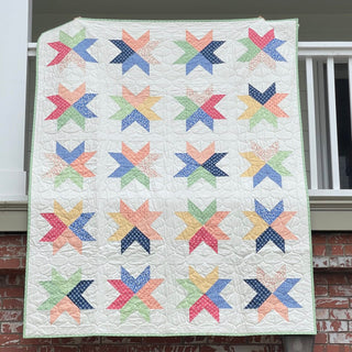 Beaming Quilt Pattern (Download) by Homemade Emily Jane showing a colorful modern star quilt with playful geometric blocks in pastel and jewel tones