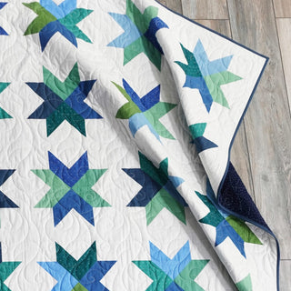 Beaming Quilt Pattern (Download) by Homemade Emily Jane featuring blue and green geometric star blocks on a white quilt background