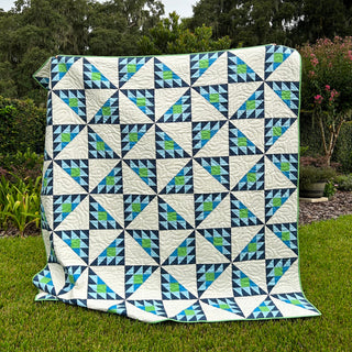 Brazen Quilt Pattern (Download) by Homemade Emily Jane featuring a bold modern geometric quilt in navy teal green and white triangles outdoors