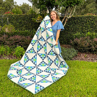 Brazen Quilt Pattern (Download) by Homemade Emily Jane featuring a modern geometric quilt with bold blue green and white triangle designs outdoors