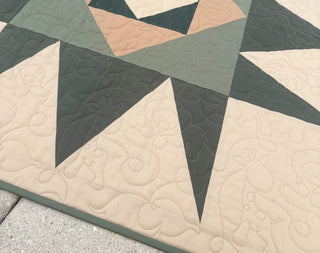 Catalyst Quilt Pattern (Download) by Homemade Emily Jane showing a modern geometric quilt in green cream and peach with bold angular shapes and flowing quilting