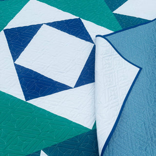 Catalyst Quilt Pattern (Download) by Homemade Emily Jane featuring a modern geometric quilt in teal blue and white with bold angular shapes and detailed quilting