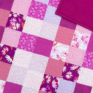 Doubled Up Quilt Pattern (Download) by Homemade Emily Jane featuring a playful modern quilt with layered geometric squares in pink purple and floral fabrics