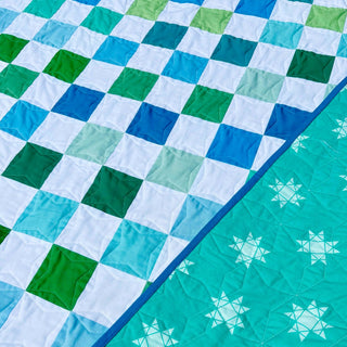 Doubled Up Quilt Pattern (Download) by Homemade Emily Jane featuring a modern quilt with layered blue and green geometric squares and bold movement