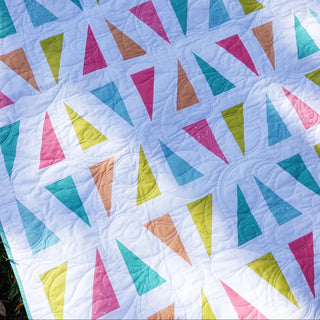 Jubilant Quilt Pattern (Download) by Homemade Emily Jane featuring colorful geometric triangles on a soft white background in a modern quilt design