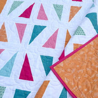 Jubilant Quilt Pattern (Download) by Homemade Emily Jane featuring colorful triangular quilt blocks in pink teal orange and white modern quilting design