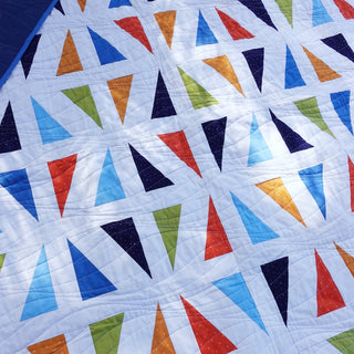 Jubilant Quilt Pattern (Download) by Homemade Emily Jane, a modern quilt pattern featuring colorful triangle shapes on a white background.