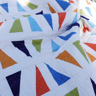 Jubilant Quilt Pattern (Download) by Homemade Emily Jane featuring a modern quilt with colorful bold triangles and airy negative space