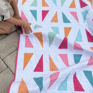 Jubilant Quilt Pattern (Download) by Homemade Emily Jane featuring a colorful modern quilt with bold geometric triangles and playful negative space
