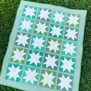 Keepsake Quilt Pattern (Download) by Homemade Emily Jane, featuring a modern green and teal quilt with white star blocks photographed on grass