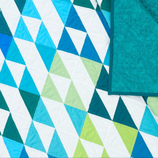 Kinetic Quilt Pattern (Download) by Homemade Emily Jane featuring a bold modern geometric quilt design in teal aqua white and lime with dynamic triangular movement