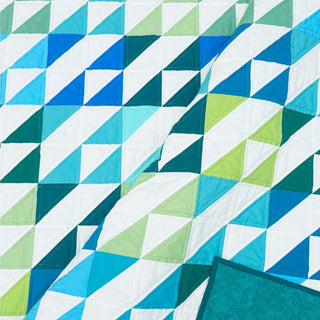 Kinetic Quilt Pattern (Download) by Homemade Emily Jane featuring a bold modern geometric quilt in teal blue green and white with dynamic movement.