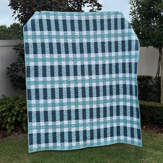 Linear Quilt Pattern (Download) by Homemade Emily Jane, a modern blue and white geometric quilt with bold vertical stripes and layered horizontal lines displayed outdoors
