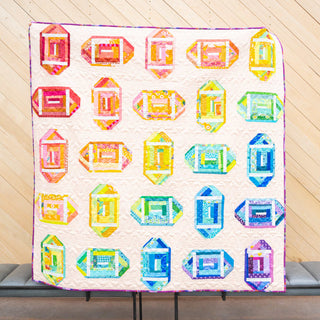 Log Cabin Lateral Quilt Pattern (Download) by Jessica Steele Design featuring colorful improv log cabin blocks arranged across a light background