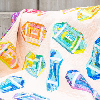 Log Cabin Lateral Quilt Pattern (Download) by Jessica Steele Design with colorful modern improv log cabin blocks on a soft pink quilt background