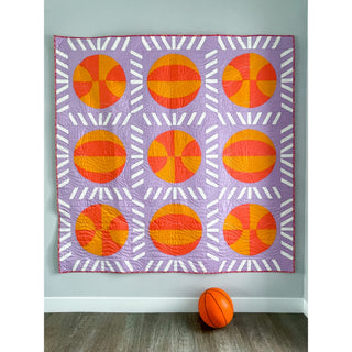 Nothin' But Net Quilt Pattern (Download) by Jessica Steele Design featuring a modern basketball quilt with orange basketball blocks and white net inspired sashing