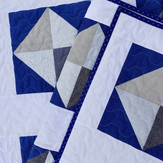 Solitaire Quilt Pattern (Download) by Homemade Emily Jane featuring a modern geometric quilt in navy blue white and gray with bold angular blocks and wave quilting