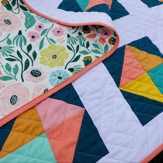 Solitaire Quilt Pattern (Download) by Homemade Emily Jane featuring a colorful modern quilt with floral backing and geometric blocks in teal coral mustard and pink